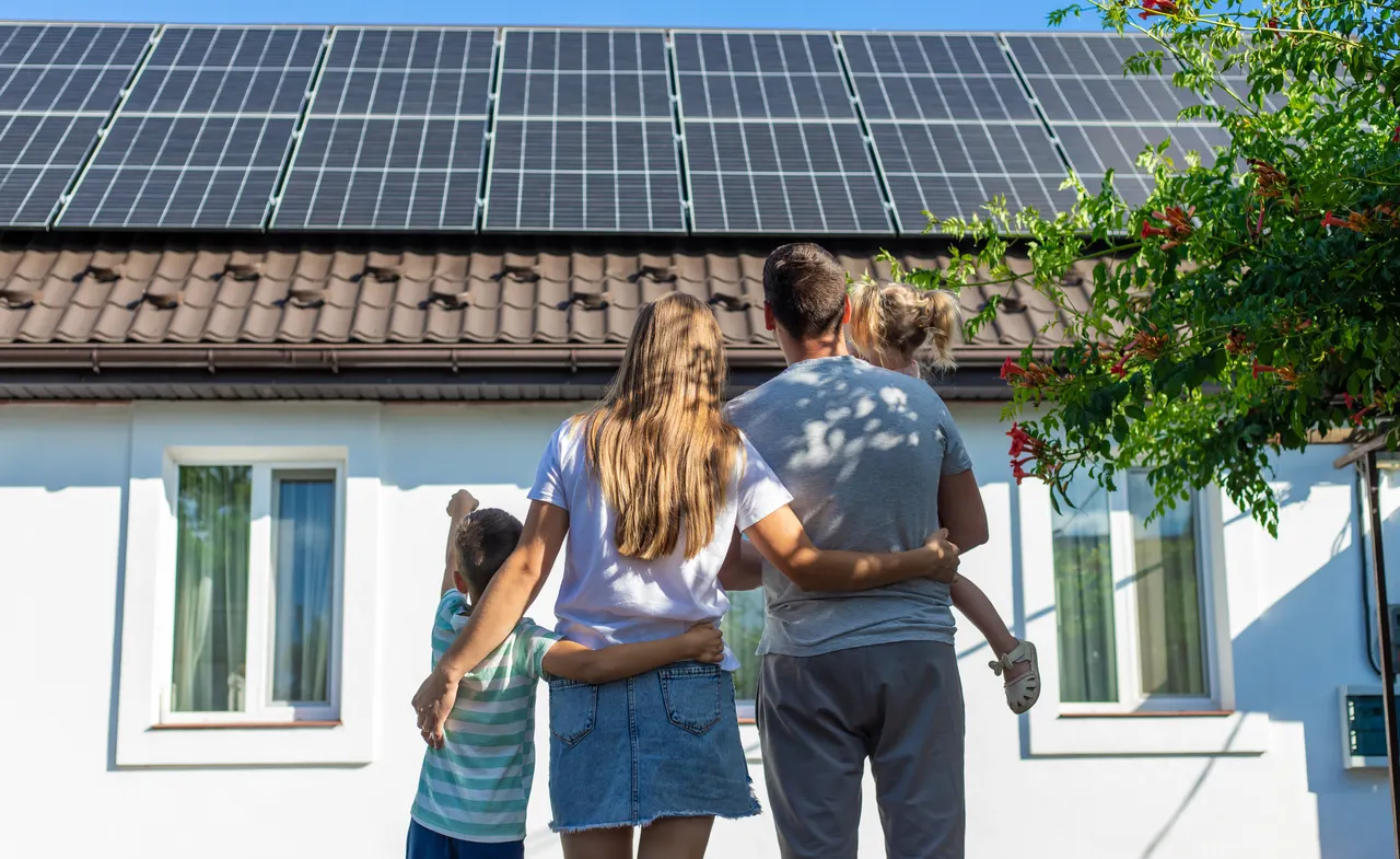 Zufriedene Familie vor Eigenheim mit Photovoltaikanlage
